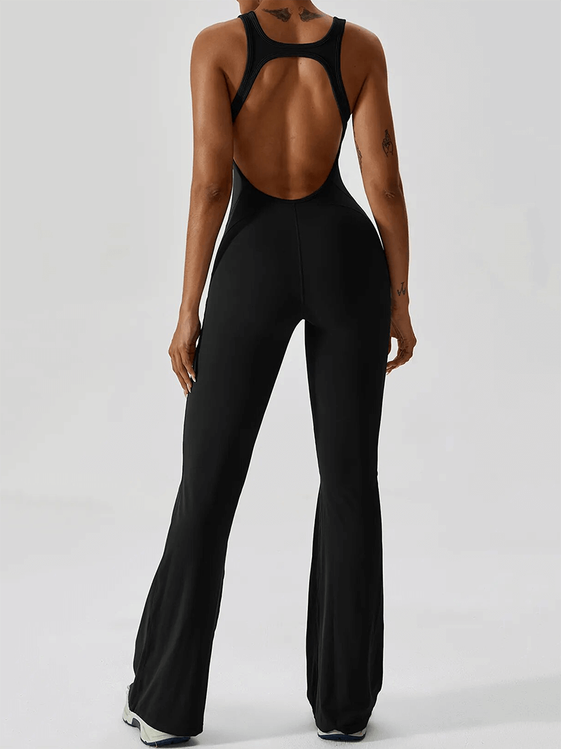Back view of a woman in a black open back fitness jumpsuit, perfect for yoga and workouts, showcasing compressed fit and flexibility.